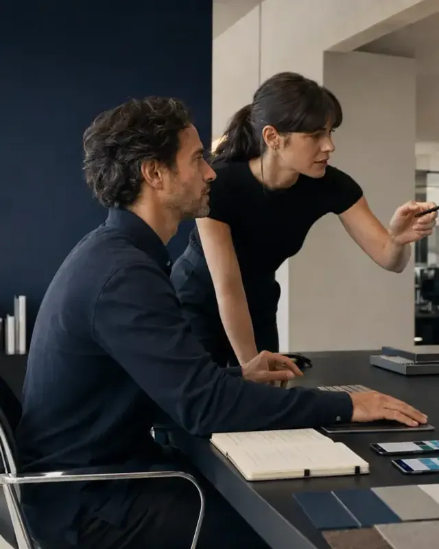 Two Mind Miami teammates working from a single screen, reviewing a project view side by side